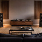 Modernes Wohnzimmer mit korrekt aufgestellten HiFi-Lautsprechern, Subwoofer und Hörplatz als Beispiel für Hifi-Lautsprecher aufstellen.