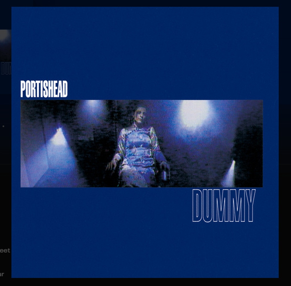 Albumcover von Portishead Dummy mit blauem Hintergrund, weißem Schriftzug und dunkler filmischer Szene im Zentrum.