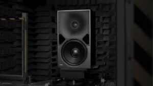 Schwarzer Genelec 8380A Aktivlautsprecher mit 15-Zoll-Tieftöner und koaxialem Mittel-Hochton-System in einem akustisch gedämmten Messraum.